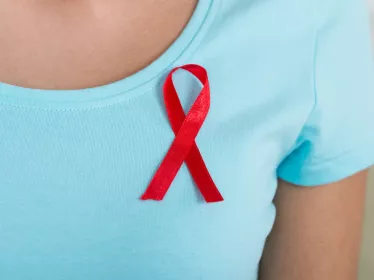 Femme portant un ruban rouge, symbole de la lutte contre le sida © Andrey Popov/ AdobeStock