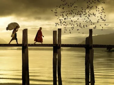 Hommes traversant un pont sous un coucher de soleil